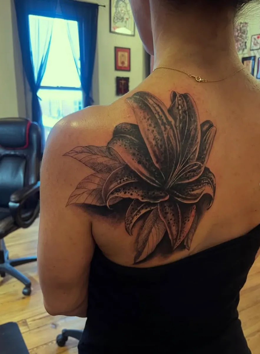 Black and grey lily shoulder tattoo by Abby Christ at True North Tattoo in Lancaster, PA