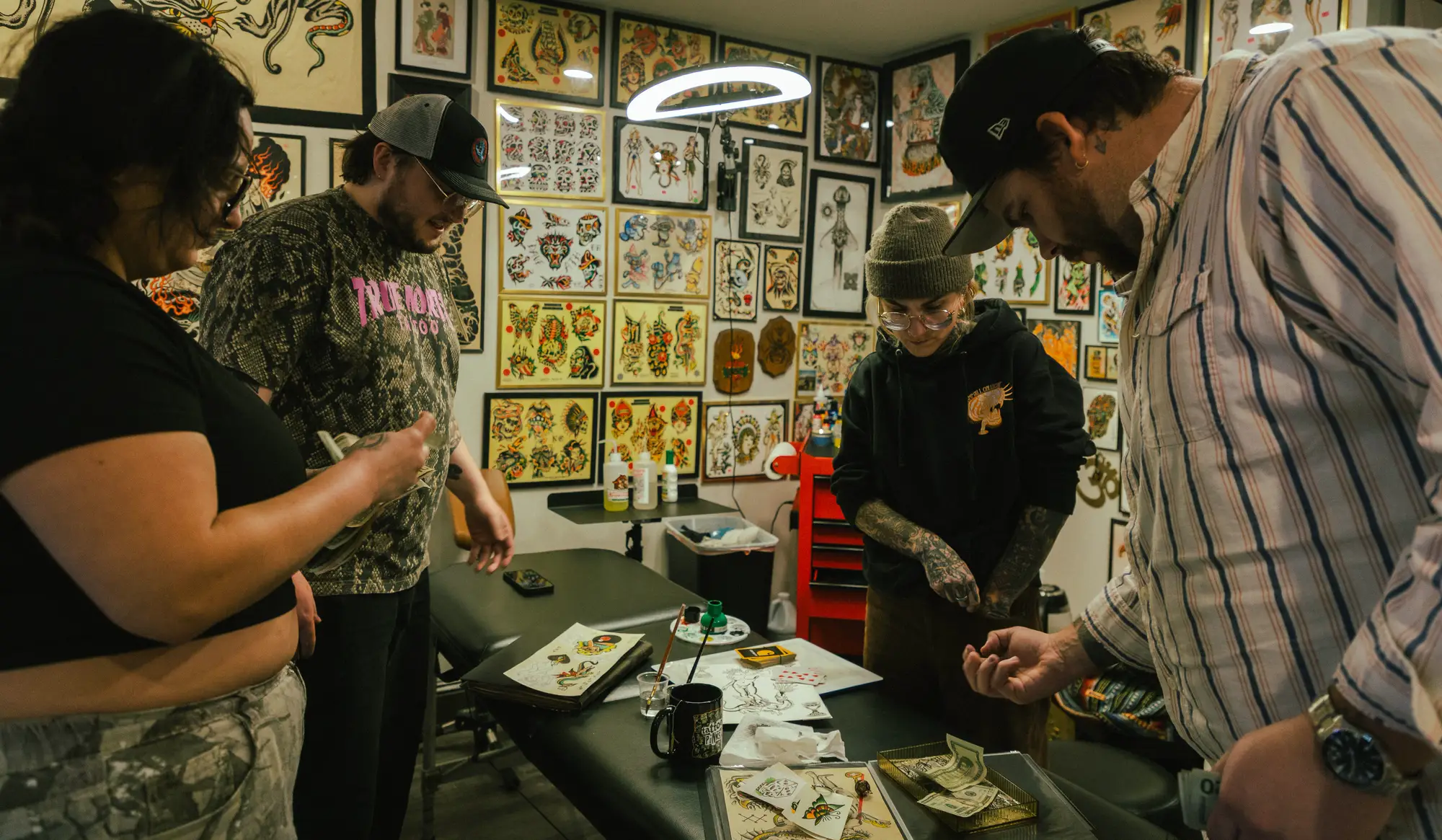 Artists and clients on the floor at True North Tattoo in Lancaster, PA, in front of the flash wall
